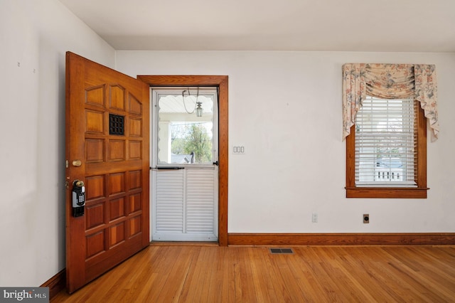 foyer entrance with light wood-style floors, visible vents, and baseboards