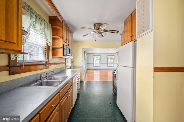 kitchen featuring a ceiling fan, open shelves, a sink, stainless steel microwave, and freestanding refrigerator