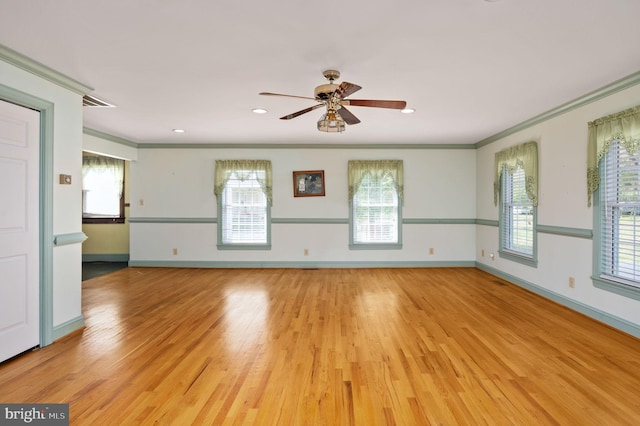 spare room with light wood-style flooring, baseboards, ceiling fan, and crown molding