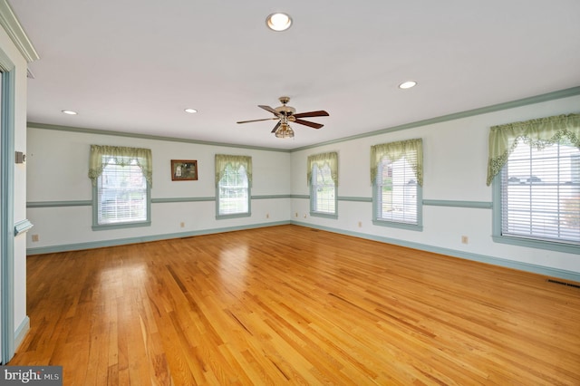 empty room featuring light wood-type flooring, baseboards, ceiling fan, and crown molding