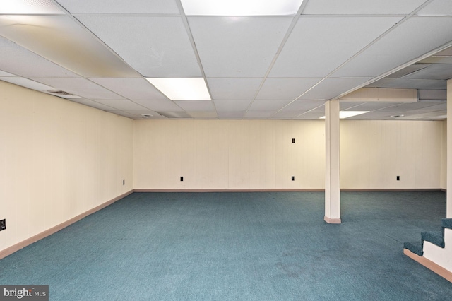finished below grade area with stairs, carpet floors, baseboards, visible vents, and a paneled ceiling