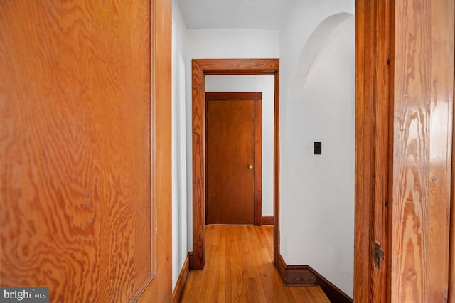 hall with light wood-type flooring and baseboards