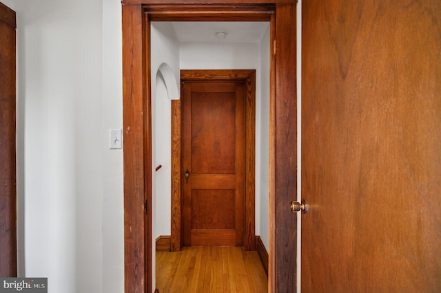 hallway featuring baseboards and wood finished floors