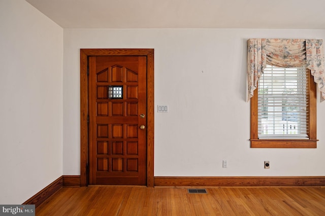 foyer entrance with wood finished floors, visible vents, and baseboards