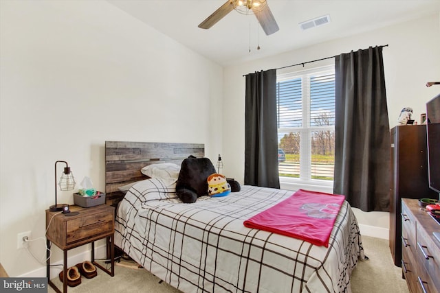 bedroom featuring visible vents, baseboards, a ceiling fan, and light carpet