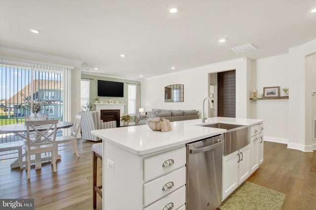 kitchen featuring white cabinets, a wealth of natural light, wood finished floors, and dishwasher