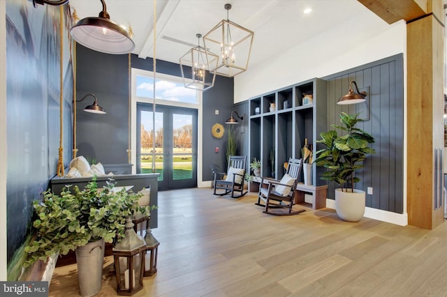 mudroom featuring a notable chandelier, a high ceiling, french doors, and wood finished floors