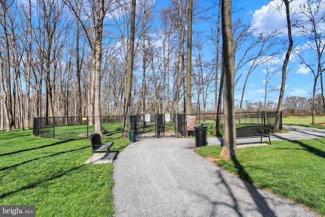 view of home's community featuring fence, a gate, and a lawn