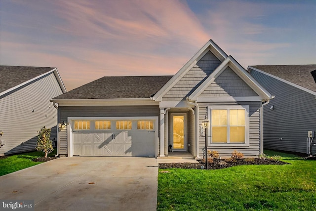 craftsman house featuring an attached garage, roof with shingles, driveway, and a front lawn