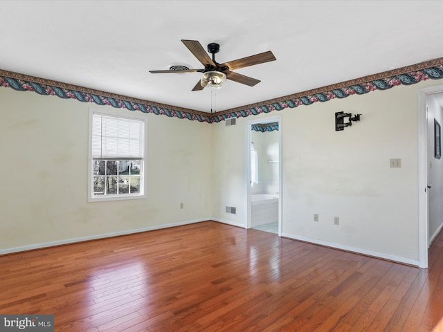 spare room featuring baseboards, a ceiling fan, visible vents, and hardwood / wood-style flooring