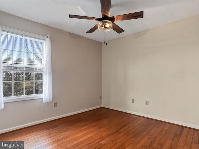 empty room featuring baseboards, hardwood / wood-style floors, and a ceiling fan