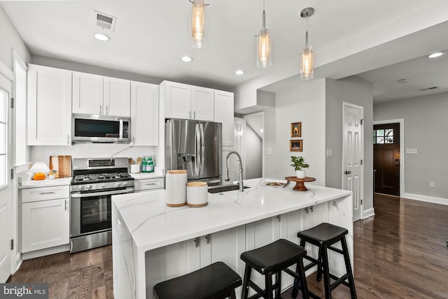 kitchen featuring visible vents, dark wood-type flooring, white cabinetry, a sink, and appliances with stainless steel finishes