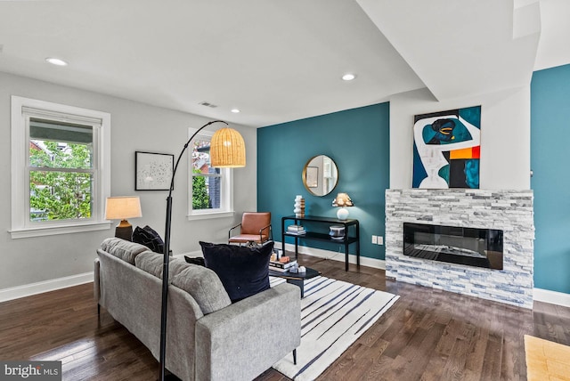 living room with visible vents, a fireplace, wood finished floors, baseboards, and recessed lighting