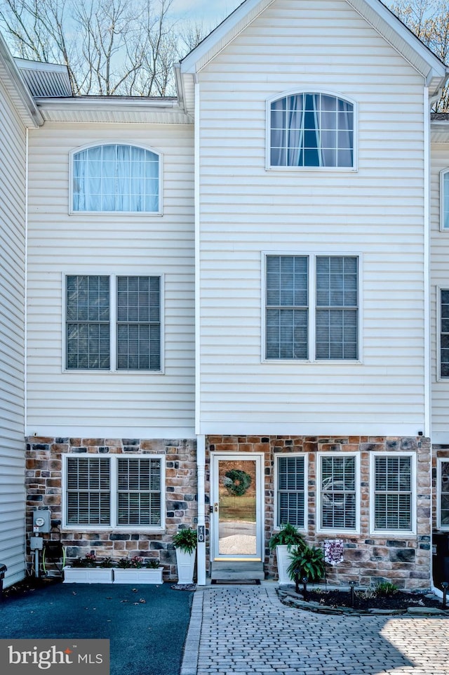 townhome / multi-family property featuring stone siding