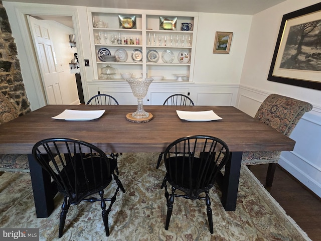 2531 Pickwick Rd, Baltimore, MD 21207 - dining room featuring wainscoting, built in shelves, and a decorative wall