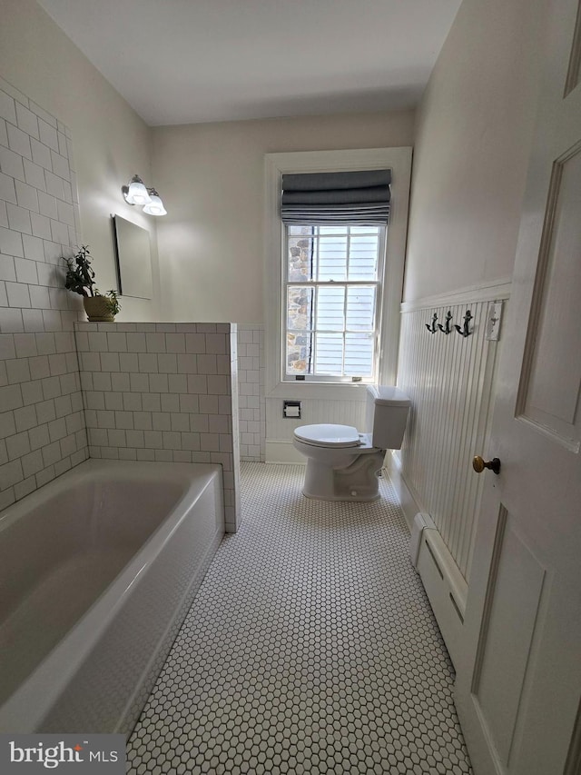 2531 Pickwick Rd, Baltimore, MD 21207 - full bathroom featuring a baseboard heating unit, toilet, a bathing tub, and wainscoting