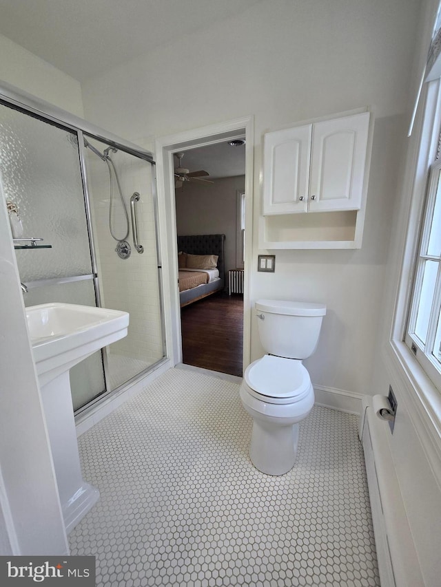 2531 Pickwick Rd, Baltimore, MD 21207 - ensuite bathroom featuring radiator heating unit, tile patterned floors, ensuite bathroom, a stall shower, and toilet