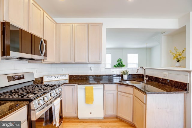 8114 Rainwater Cir, Manassas, VA 20111 - kitchen featuring backsplash, dark stone counters, stainless steel appliances, and a sink