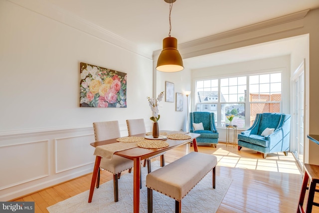 8114 Rainwater Cir, Manassas, VA 20111 - dining room featuring crown molding, light wood-style flooring, a wainscoted wall, and a decorative wall