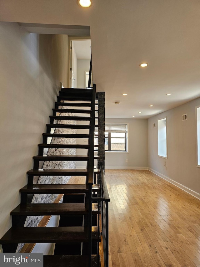 stairway with visible vents, wood-type flooring, baseboards, and recessed lighting
