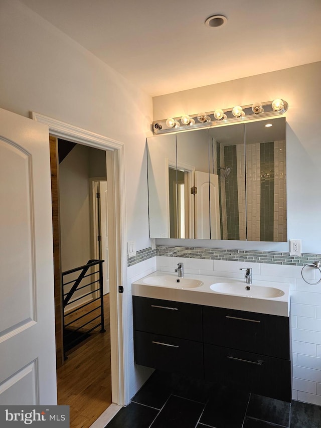 full bathroom with a sink, tasteful backsplash, double vanity, and wood finished floors
