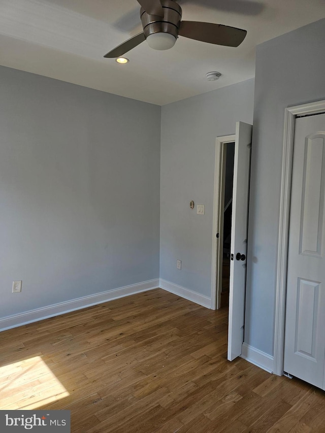 unfurnished bedroom with wood finished floors, ceiling fan, and baseboards