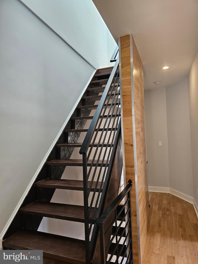 stairway with recessed lighting, baseboards, and wood finished floors