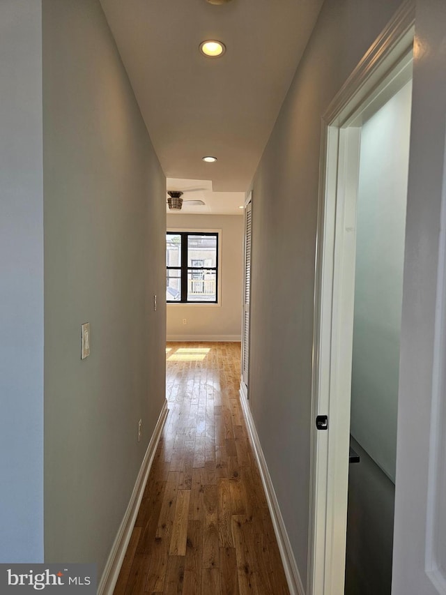 corridor with recessed lighting, baseboards, and hardwood / wood-style floors