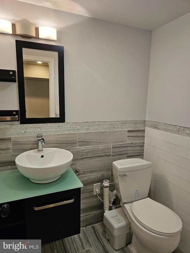 bathroom with toilet, vanity, and wainscoting