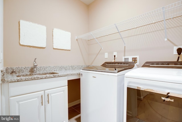 laundry area with washing machine and clothes dryer, tile patterned floors, and a sink