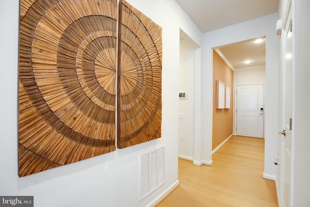 hallway with light wood-style flooring, baseboards, ornamental molding, visible vents, and recessed lighting