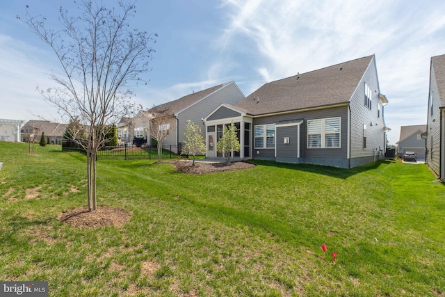 back of house with fence and a yard