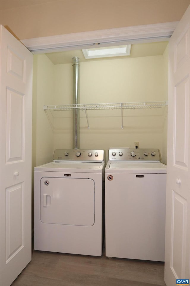 laundry area featuring laundry area, wood finished floors, and washing machine and clothes dryer