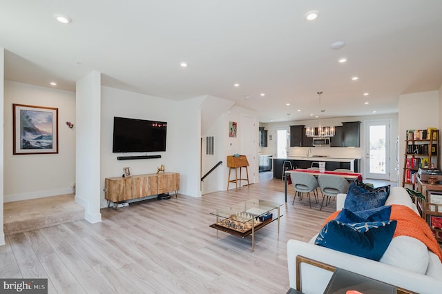 living area featuring light wood-type flooring, a chandelier, and recessed lighting