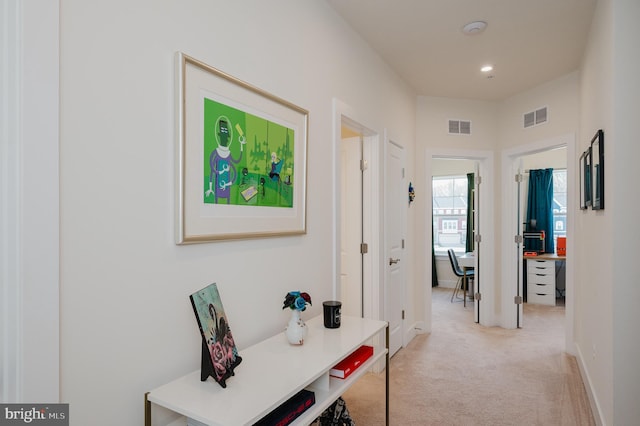 hallway featuring recessed lighting, visible vents, light colored carpet, and baseboards