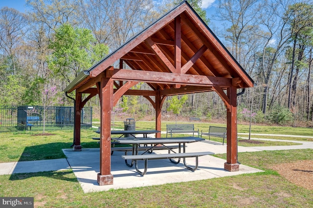 view of community featuring a yard, a gazebo, fence, and a patio area