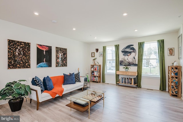living room featuring baseboards, recessed lighting, and wood finished floors