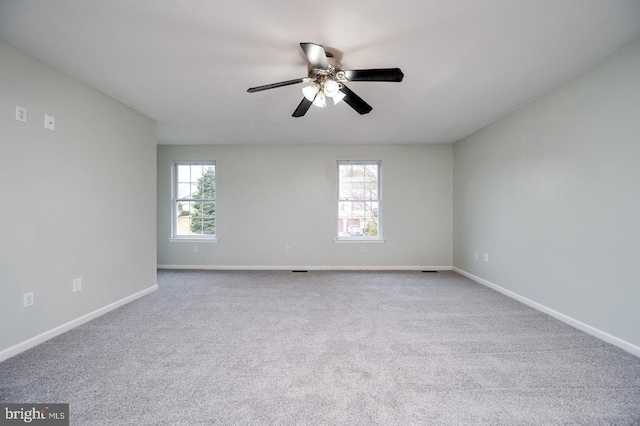 unfurnished room featuring carpet floors, baseboards, a ceiling fan, and a wealth of natural light