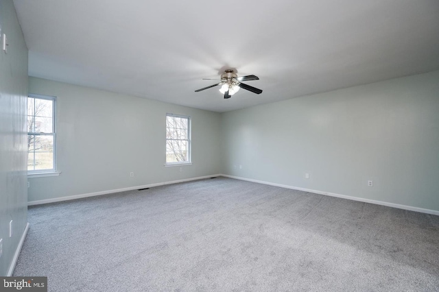 spare room featuring carpet, baseboards, and a ceiling fan