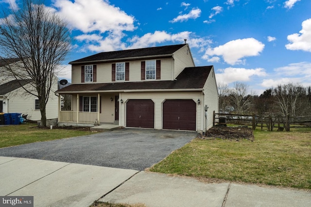 view of front of home featuring a garage, a front yard, driveway, and covered porch