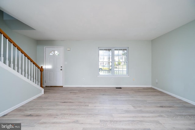 entryway featuring stairway, visible vents, baseboards, and light wood finished floors