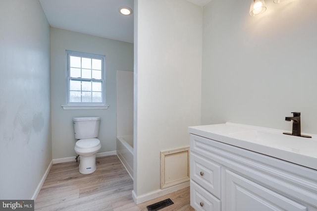 full bath featuring a tub, visible vents, toilet, and wood finished floors
