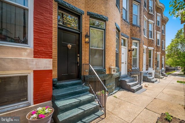 view of exterior entry with brick siding