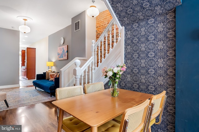 dining area featuring stairs, wood finished floors, and baseboards