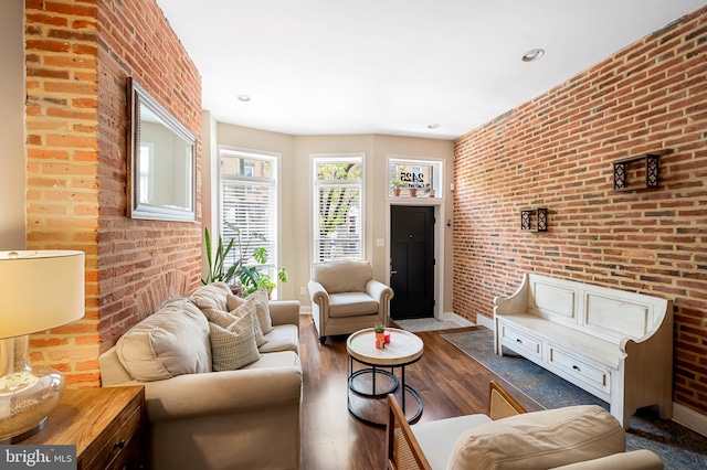 living room with brick wall, baseboards, wood finished floors, and recessed lighting