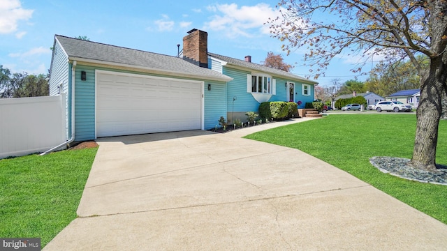 exterior space with a front yard, an attached garage, a chimney, fence, and driveway