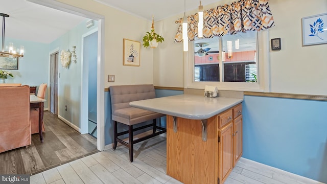 dining area with baseboards, light wood finished floors, and a notable chandelier