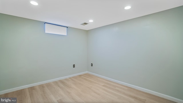 finished below grade area featuring light wood-style floors, baseboards, visible vents, and recessed lighting