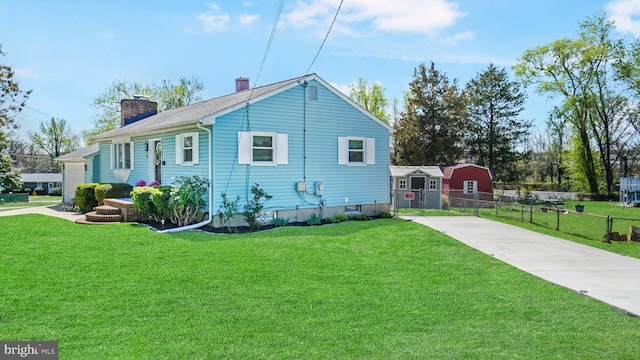 view of side of property with a yard, fence, driveway, and a chimney