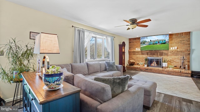living area with a fireplace, dark wood-style floors, and ceiling fan